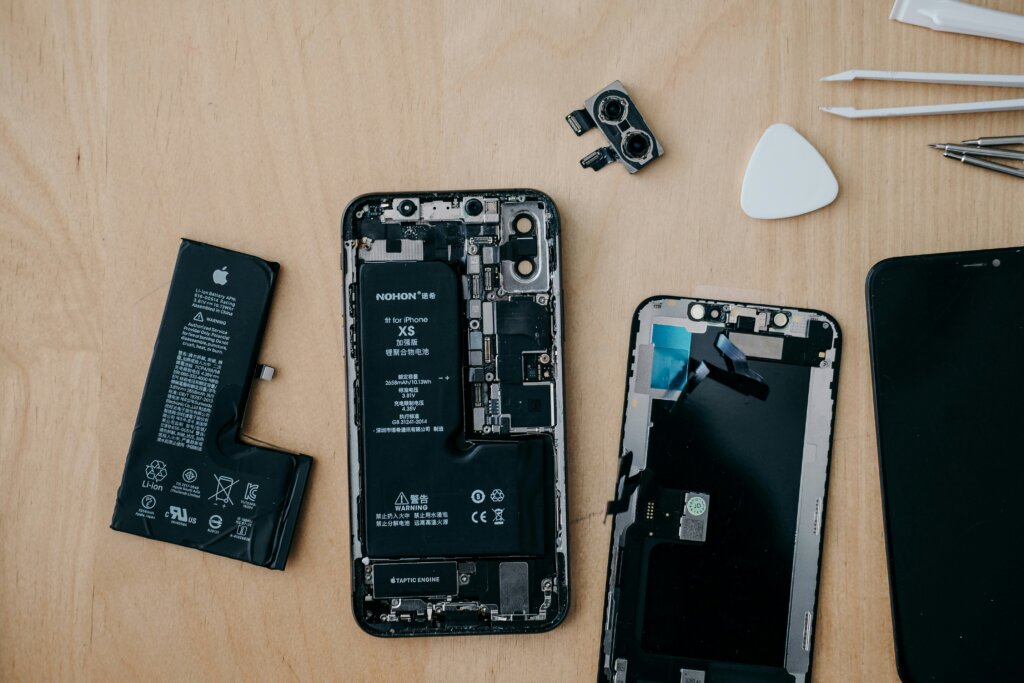 A phone being repaired lays on a desk.
